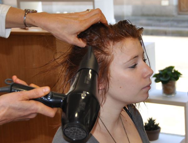 Jeune femme se faisant sécher les cheveux